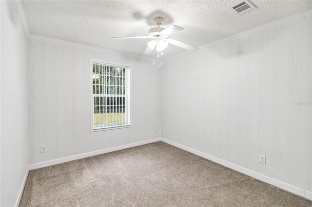 spare room with a ceiling fan, carpet, a textured ceiling, visible vents, and crown molding