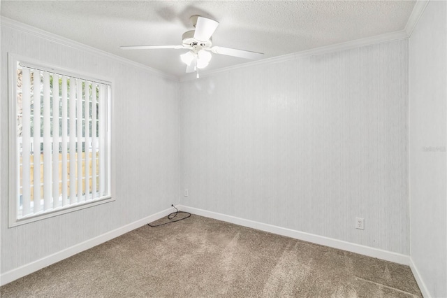 spare room with ornamental molding, a textured ceiling, carpet floors, a ceiling fan, and baseboards