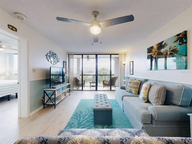 living room with floor to ceiling windows, light hardwood / wood-style floors, a textured ceiling, and ceiling fan