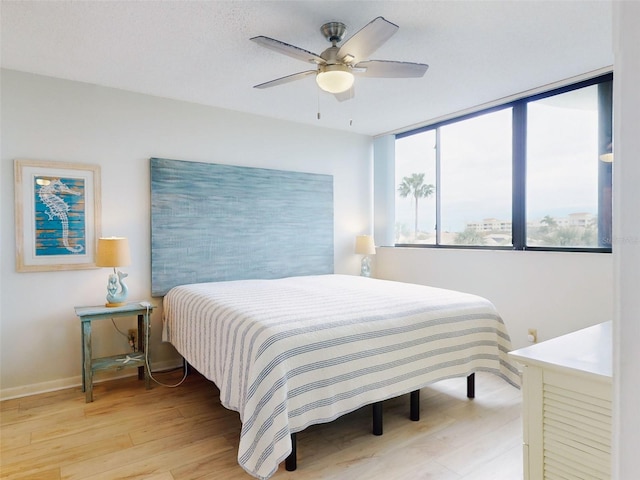 bedroom with light hardwood / wood-style flooring and ceiling fan