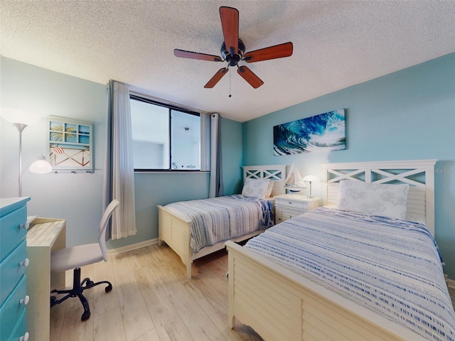 bedroom featuring light wood-type flooring, ceiling fan, and a textured ceiling