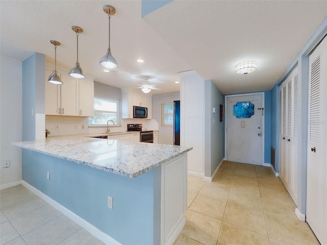 kitchen featuring white cabinetry, light stone counters, hanging light fixtures, appliances with stainless steel finishes, and kitchen peninsula