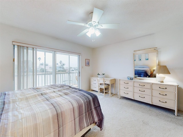 carpeted bedroom with a water view, ceiling fan, access to exterior, and a textured ceiling