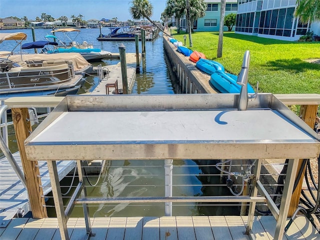 dock area featuring a lawn and a water view