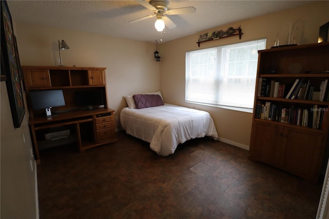 bedroom featuring ceiling fan and a textured ceiling