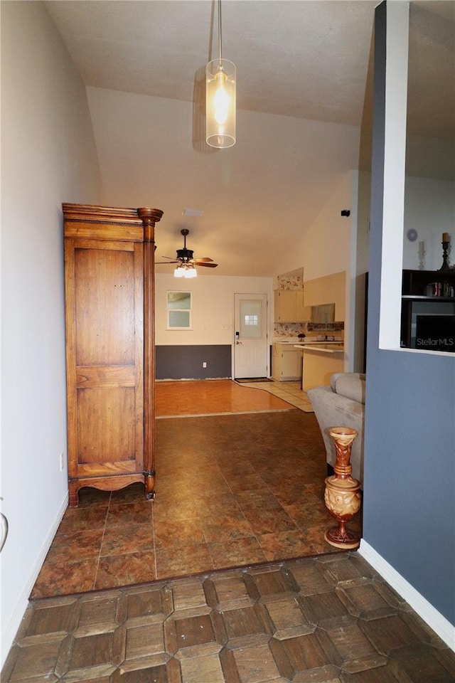 interior space with decorative light fixtures, vaulted ceiling, and ceiling fan