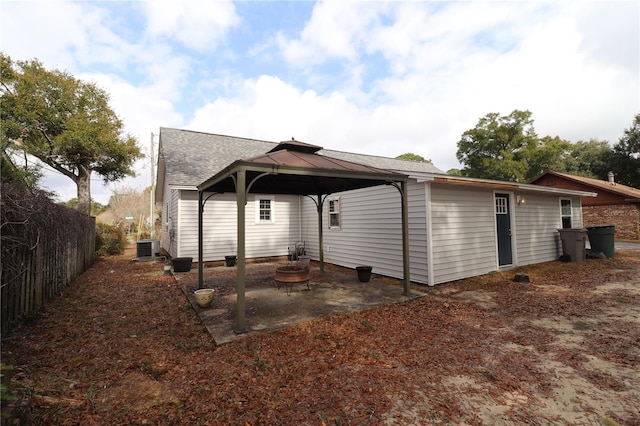 back of property featuring a gazebo, central air condition unit, and an outdoor fire pit