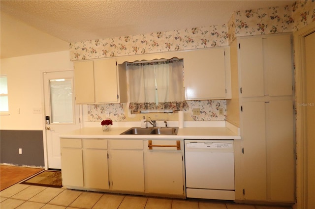 kitchen featuring light tile patterned flooring, sink, a textured ceiling, and white dishwasher