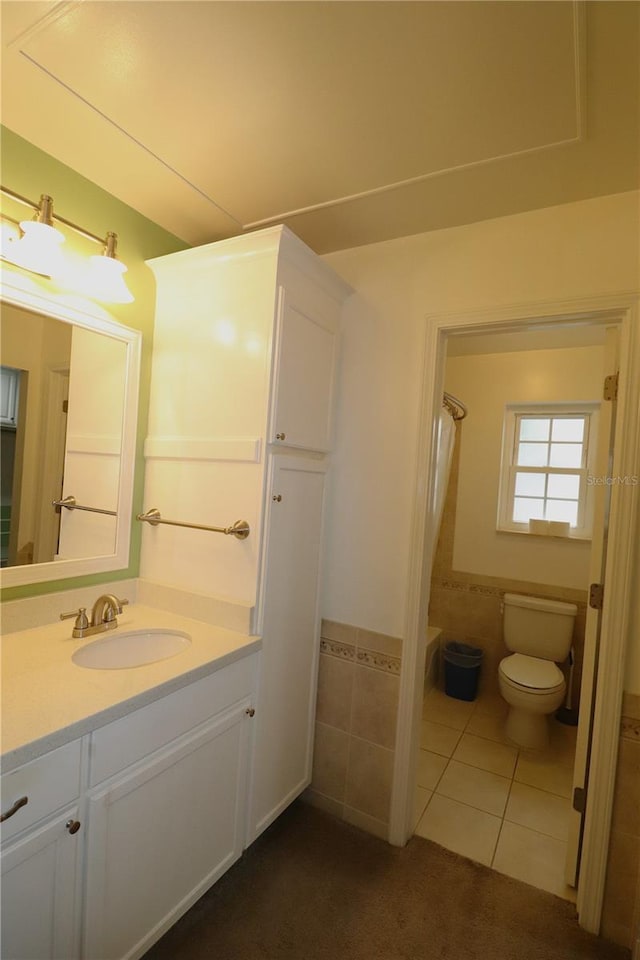 bathroom featuring vanity, tile patterned flooring, toilet, and walk in shower