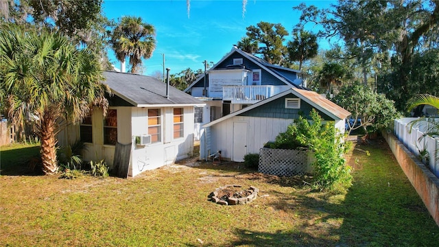 view of home's exterior with cooling unit, a yard, and a fire pit