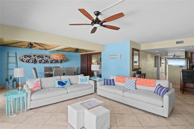 living room with light tile patterned flooring, a textured ceiling, and ceiling fan