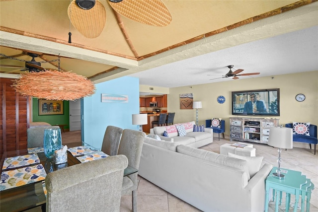 living room featuring light tile patterned flooring, ceiling fan, and a textured ceiling