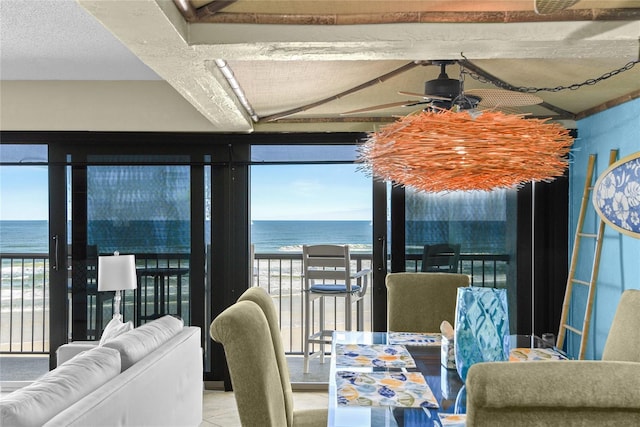 dining room featuring a water view, lofted ceiling, and ceiling fan