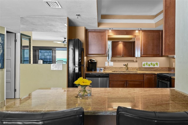 kitchen with sink, stainless steel appliances, a kitchen breakfast bar, light stone counters, and ornamental molding