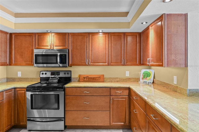 kitchen featuring ornamental molding, light stone countertops, and appliances with stainless steel finishes