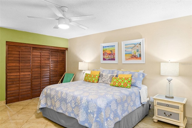 bedroom with ceiling fan, a textured ceiling, and light tile patterned flooring