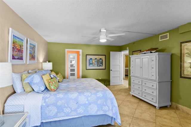 tiled bedroom featuring ceiling fan and a textured ceiling