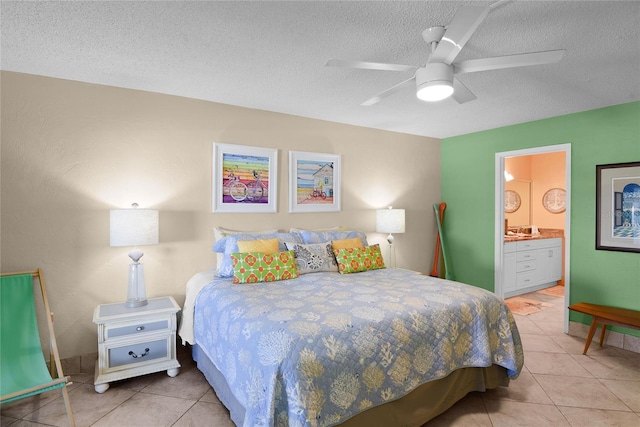 tiled bedroom with ceiling fan, a textured ceiling, and ensuite bathroom