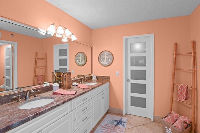 bathroom featuring tile patterned flooring, vanity, and a textured ceiling