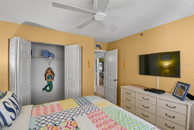 bedroom featuring ceiling fan, a closet, and a textured ceiling