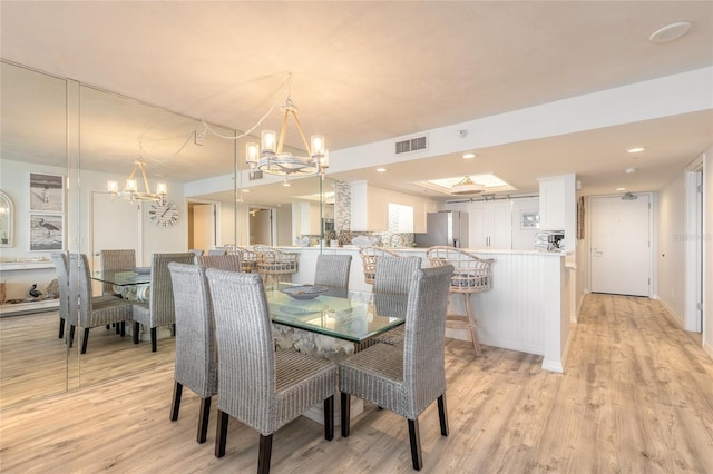 dining area featuring a chandelier and light wood-type flooring