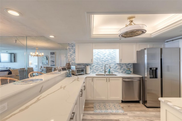 kitchen with light stone counters, sink, decorative light fixtures, and appliances with stainless steel finishes