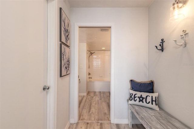 interior space with tiled shower / bath combo and hardwood / wood-style flooring