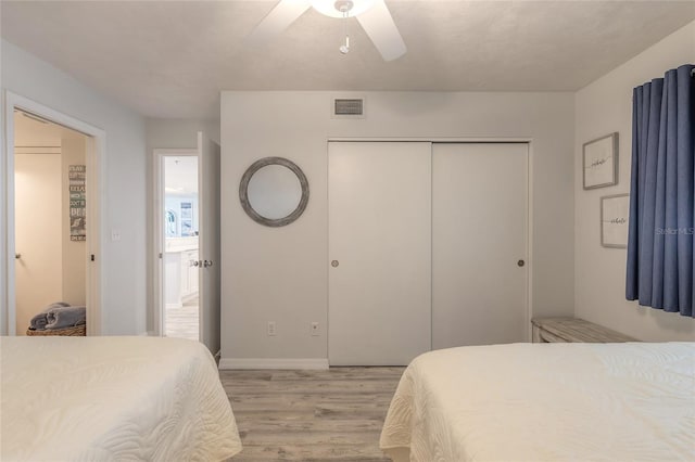 bedroom featuring light wood-type flooring, ceiling fan, and a closet