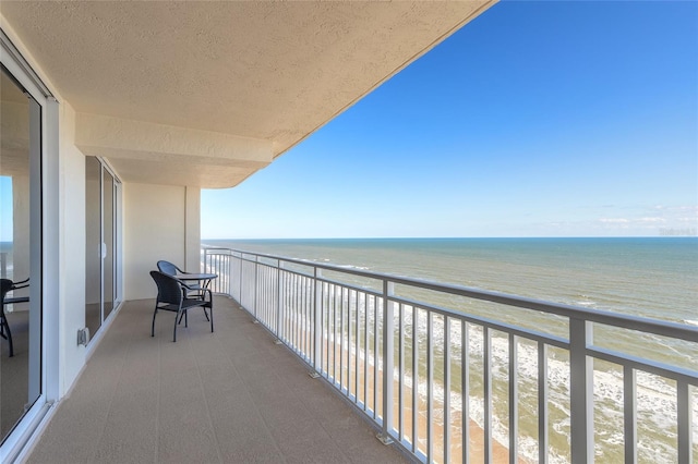 balcony featuring a water view and a view of the beach