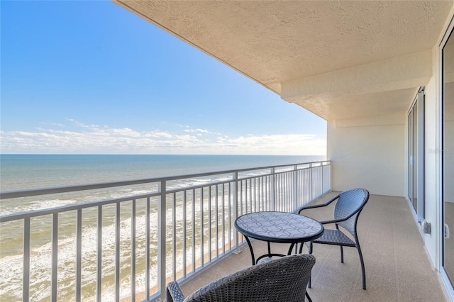 balcony featuring a water view and a beach view