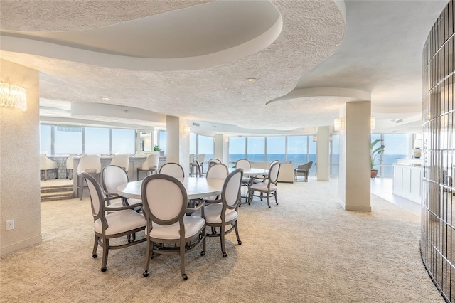 carpeted dining area featuring a water view