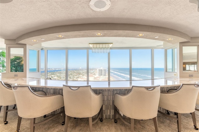 dining room with a textured ceiling and a water view