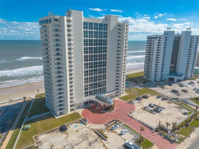 birds eye view of property featuring a water view and a beach view