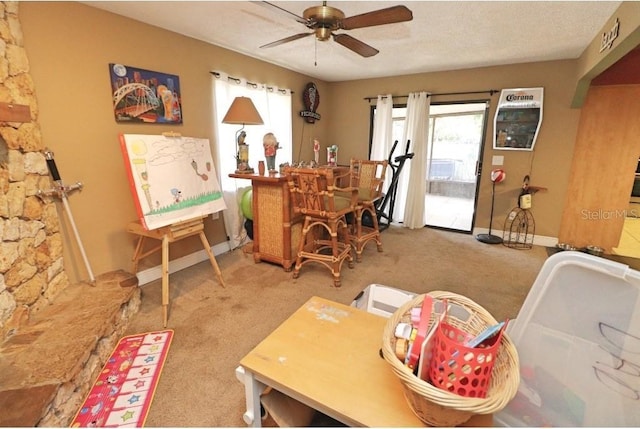 carpeted home office featuring ceiling fan