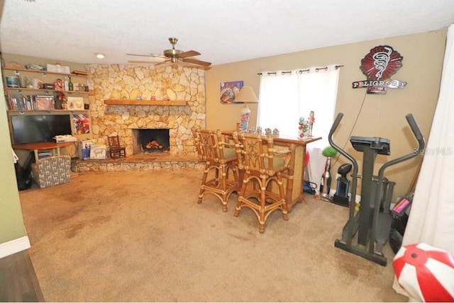 living room featuring ceiling fan, a fireplace, and carpet floors