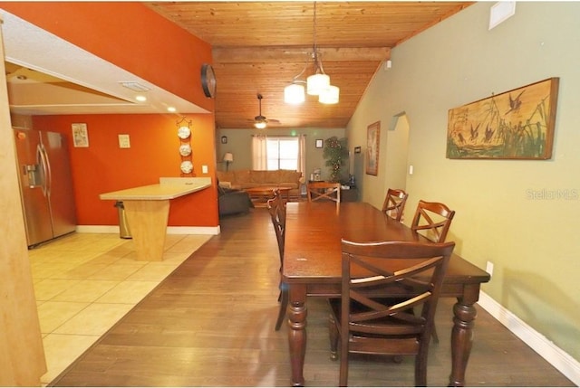 dining room featuring vaulted ceiling with beams, ceiling fan, tile patterned floors, and wooden ceiling