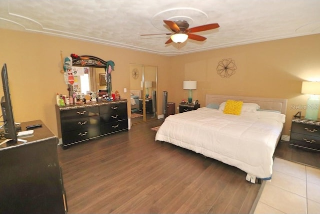 bedroom with hardwood / wood-style floors, a textured ceiling, and ceiling fan