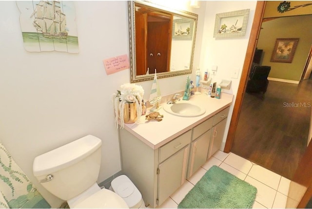 bathroom featuring vanity, tile patterned floors, and toilet