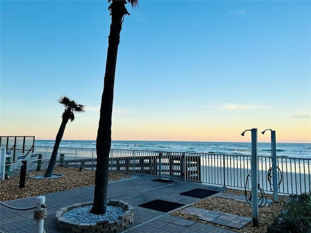 view of home's community with a water view and a beach view