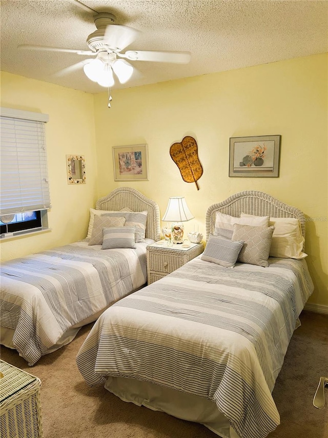 carpeted bedroom featuring ceiling fan and a textured ceiling