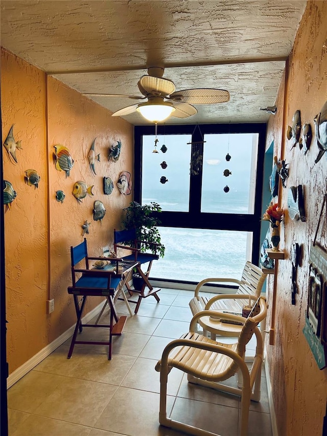 sitting room featuring floor to ceiling windows, light tile patterned floors, and ceiling fan