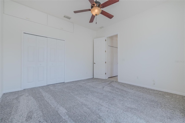 unfurnished bedroom featuring carpet floors, visible vents, baseboards, a ceiling fan, and a closet