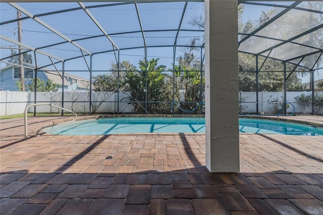 view of swimming pool featuring a fenced in pool, glass enclosure, a patio area, and a fenced backyard