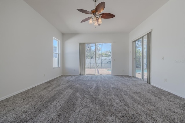 empty room with carpet flooring, a ceiling fan, and baseboards