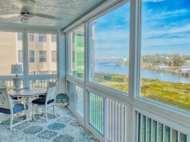 sunroom featuring a water view