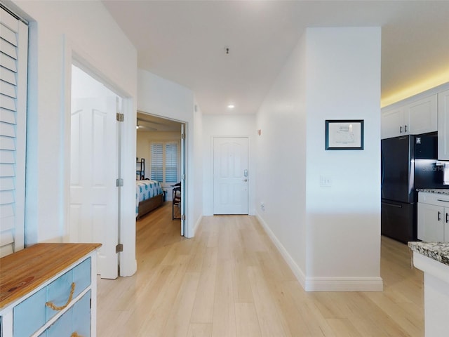 hallway with light hardwood / wood-style floors