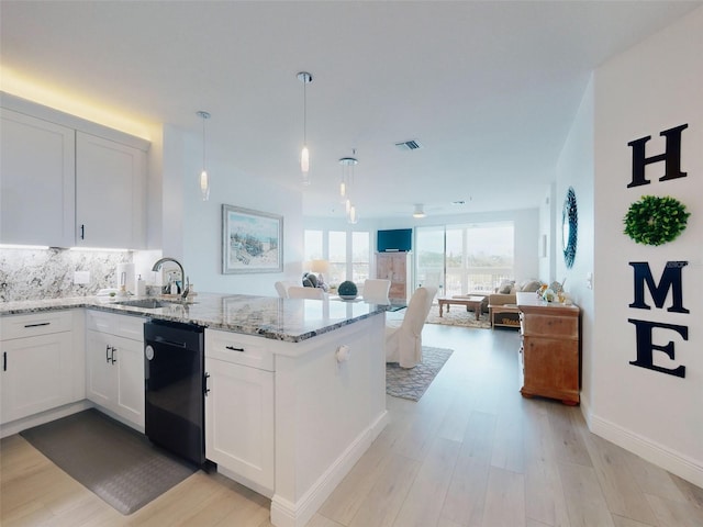 kitchen with dishwasher, sink, pendant lighting, and white cabinets