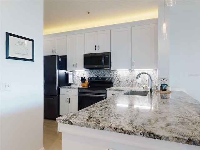 kitchen with white cabinetry, sink, black appliances, and kitchen peninsula