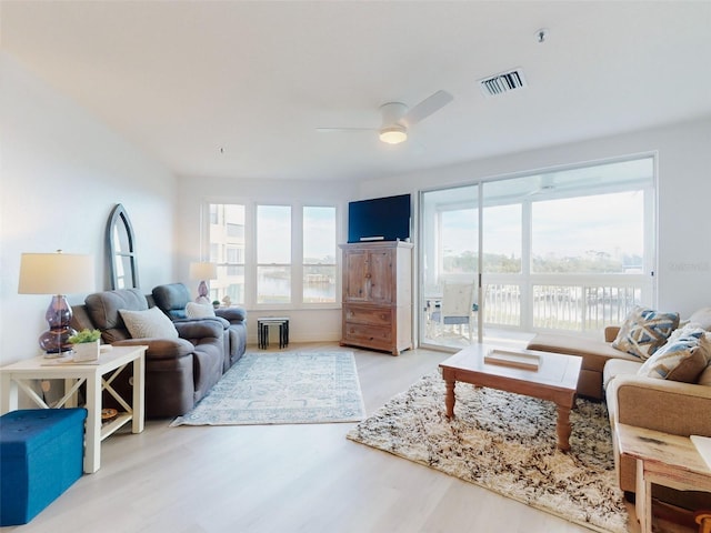 living room featuring light hardwood / wood-style flooring and ceiling fan