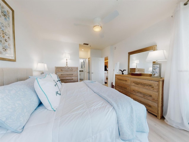 bedroom with ceiling fan, ensuite bath, and light wood-type flooring